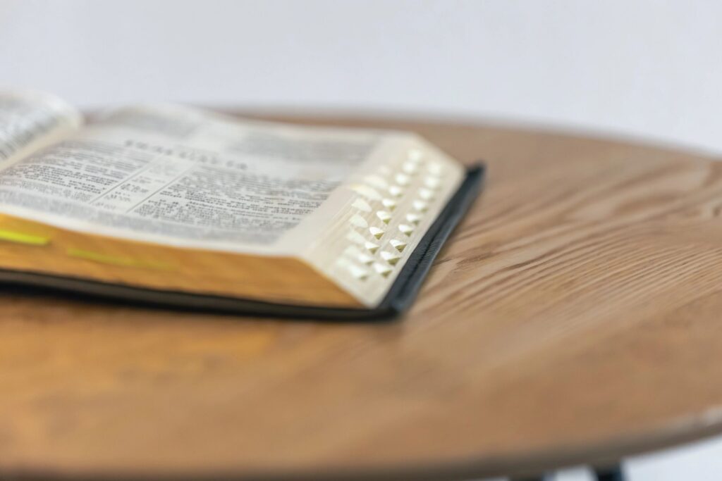 Open Bible with index tabs on wood. Calm reading.